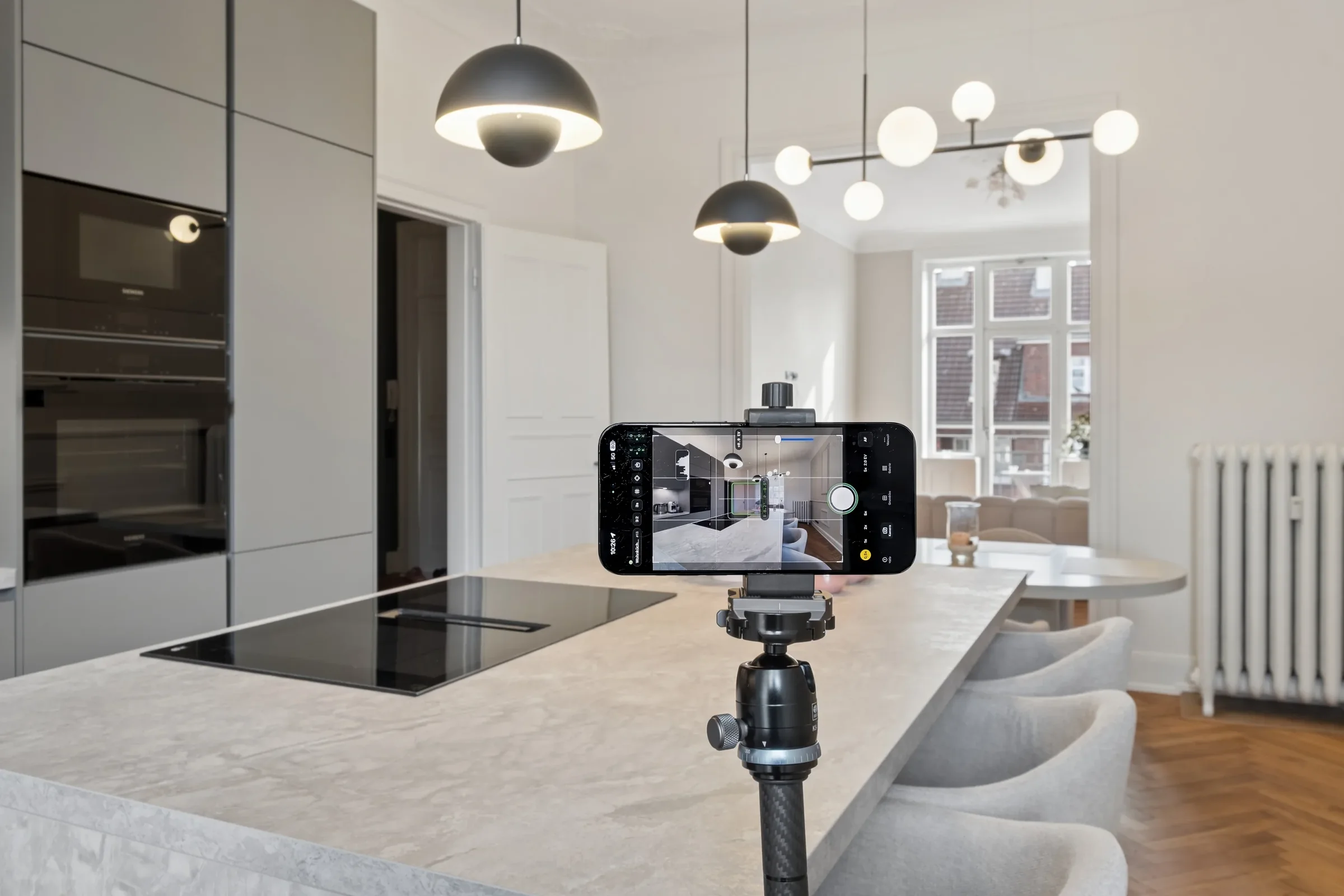 Smartphone auf einem Stativ während der Aufnahme eines Immobilienraums
